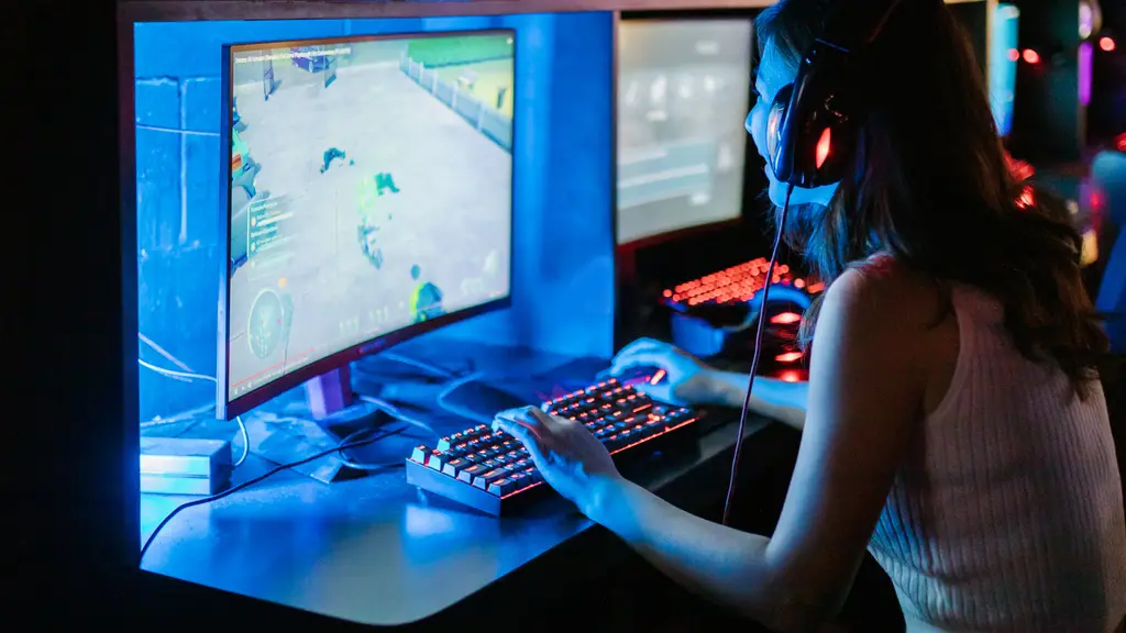Young woman playing a game at a PC lit in blue neon