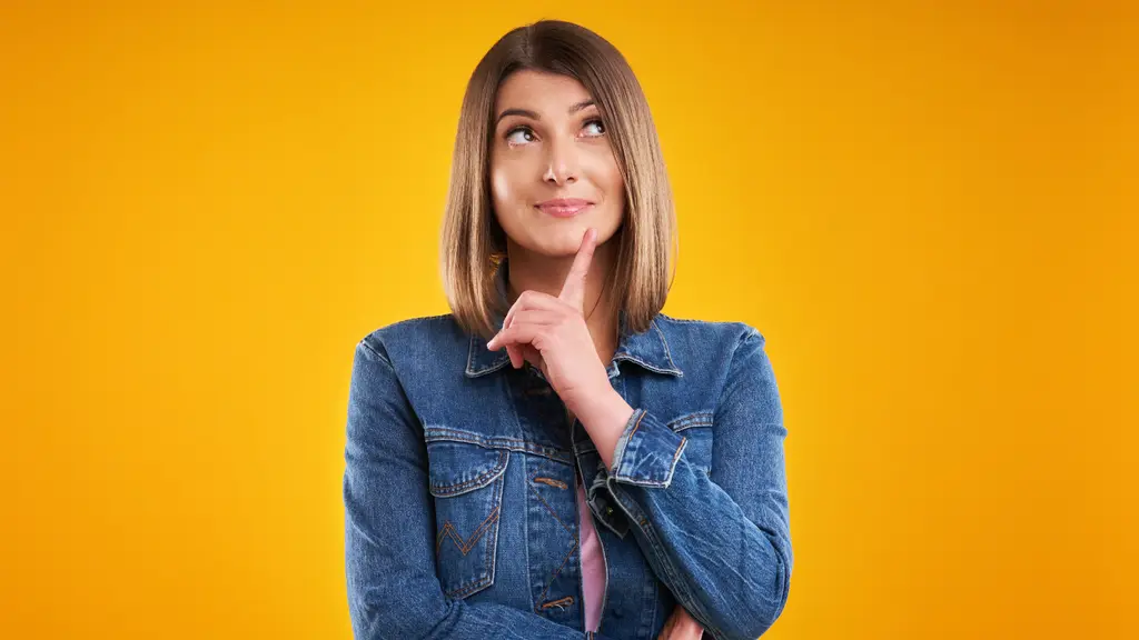 Woman in a denim jacket thinking, finger on her chin