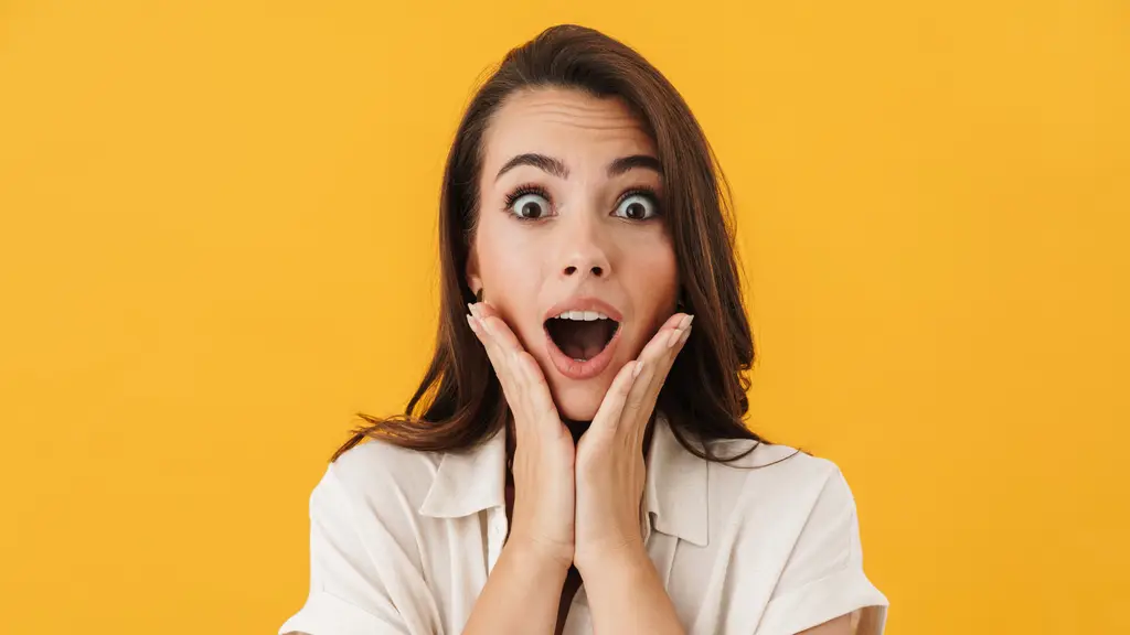 Young woman looking surprised, hands on her cheeks