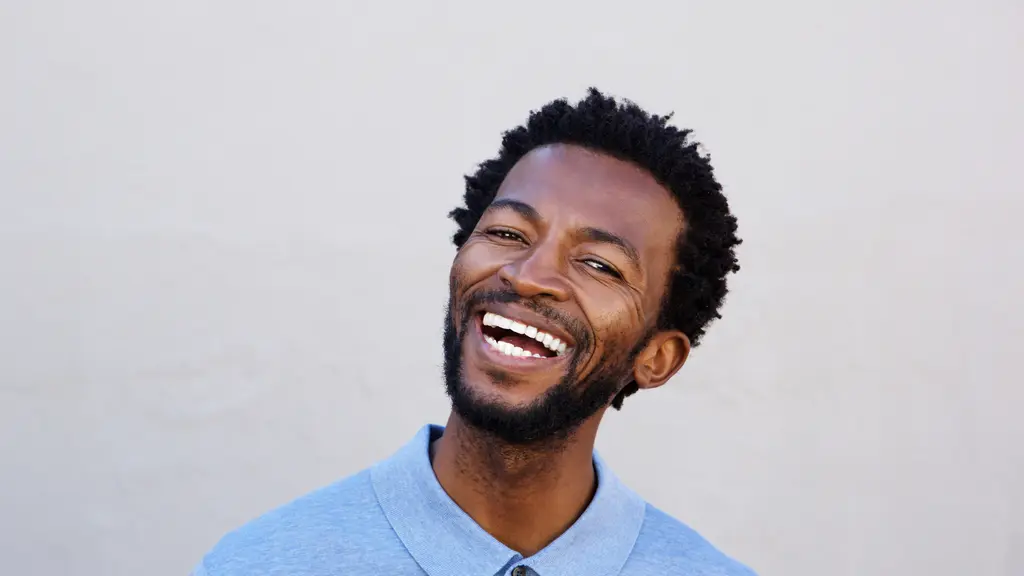 Man laughing against a light wall