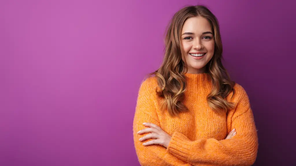 Smiling young woman in an orange sweater
