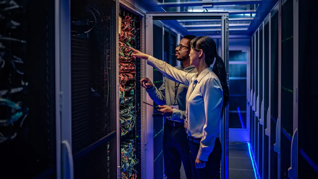 Two engineers checking network cabling in a server rack